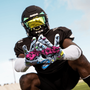 Football player holding up his Battle Sports receiver football gloves