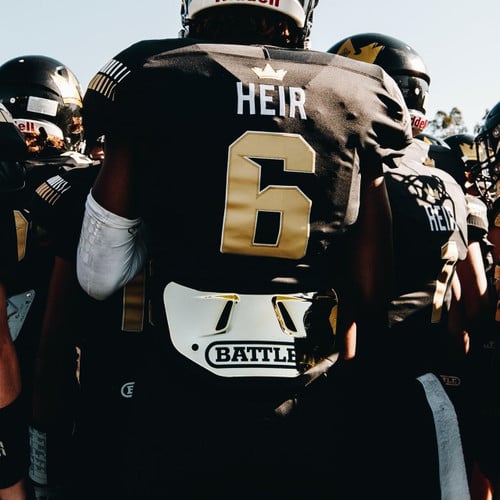 football player in a huddle wearing a battle sports back plate