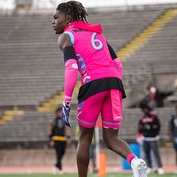 Football player in bright pink uniform with pink football towel